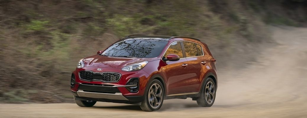 Sideview of a 2022 Kia Sportage cruising down a dusty road
